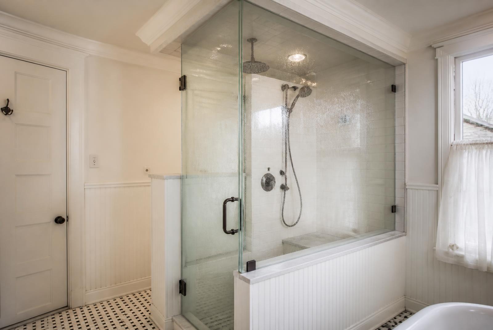 Sealed steam shower glass enclosure with oil-rubbed bronze hardware in a Spring Lake Victorian bath