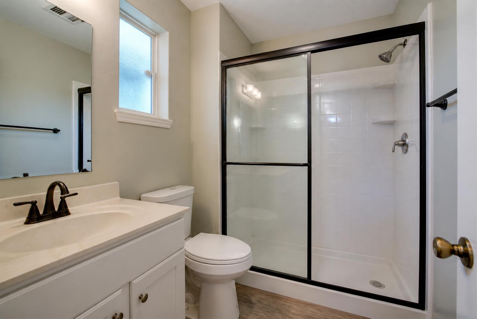 Matte black framed sliding bypass shower door in a Toms River ranch hall bathroom