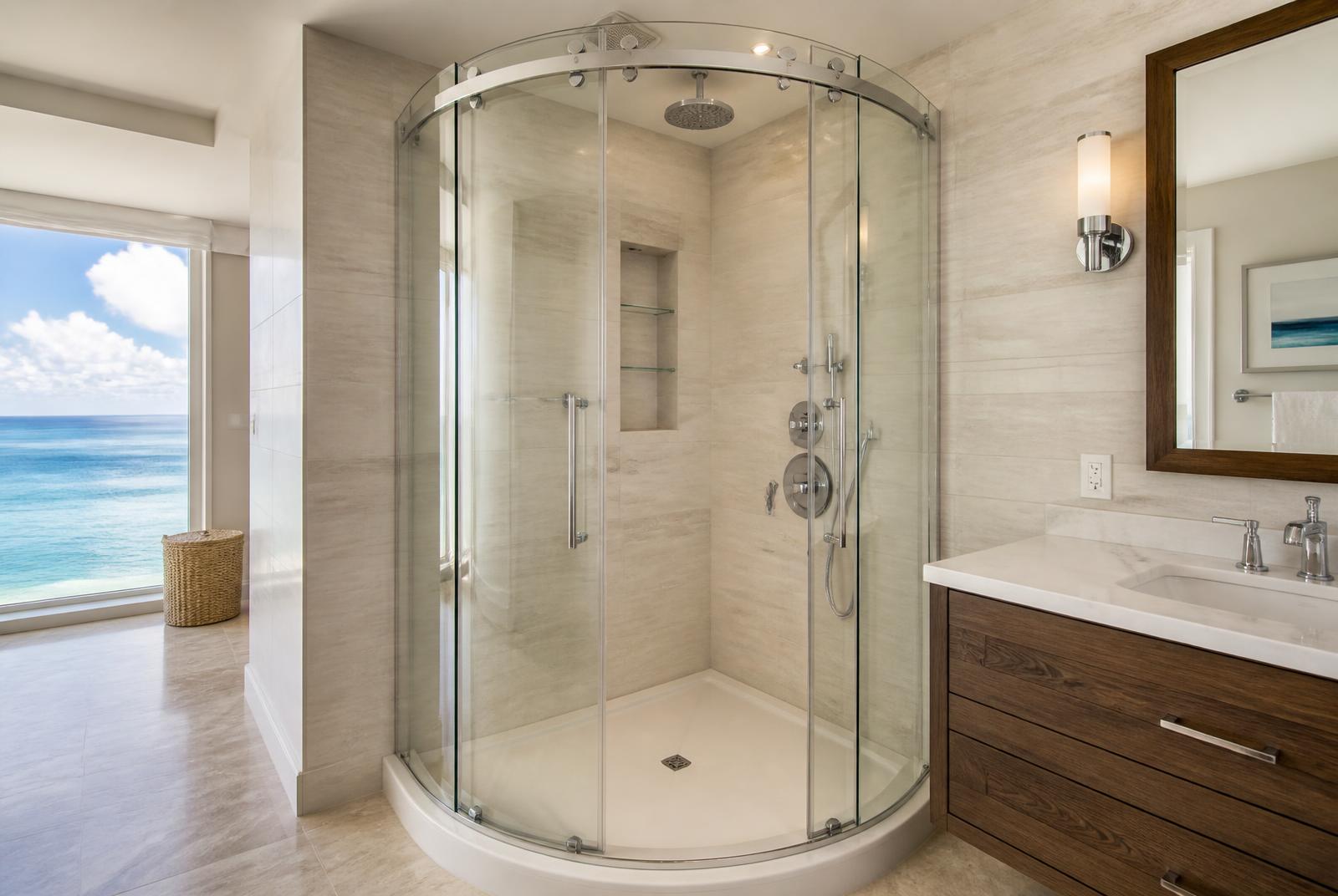 Frameless curved corner shower enclosure in a Long Branch oceanfront condo bathroom